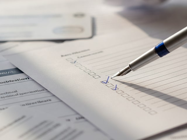 Checklist with pen and product specification sheets in natural light